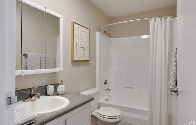 A bathroom with a toilet, sink, and bathtub.