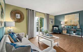 a living room with blue and green walls and a sliding glass door leading to a patio