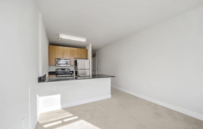 A white room with a kitchen area in the background.