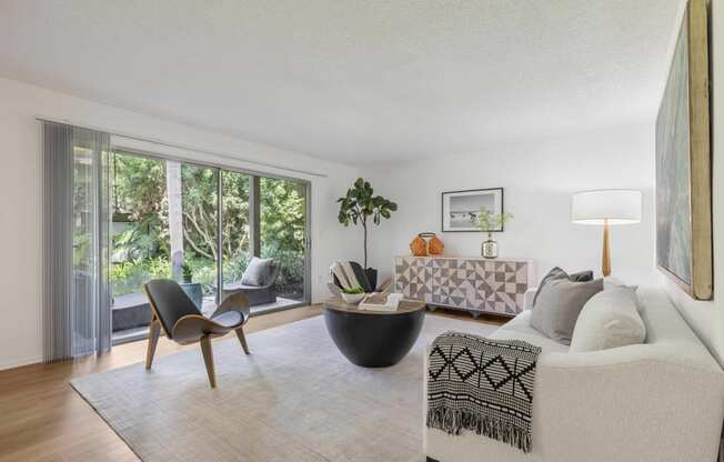 a living room with a couch and a table   and large windows