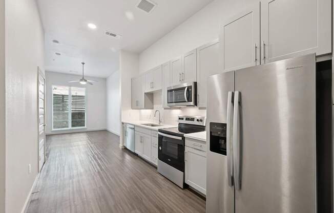 A modern kitchen with stainless steel appliances and white cabinets.