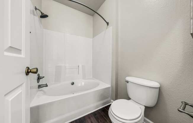 a bathroom with a toilet and a tub and a sink