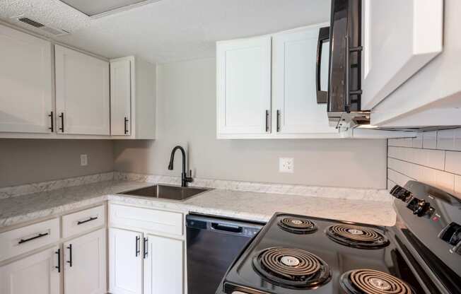 an empty kitchen with white cabinets and a stove top oven