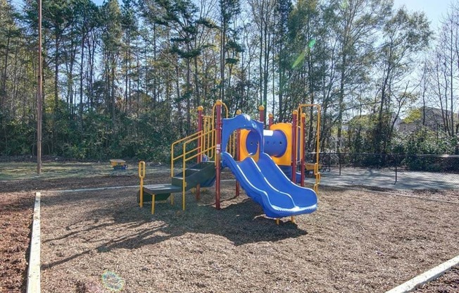 a playground with a blue and yellow slide