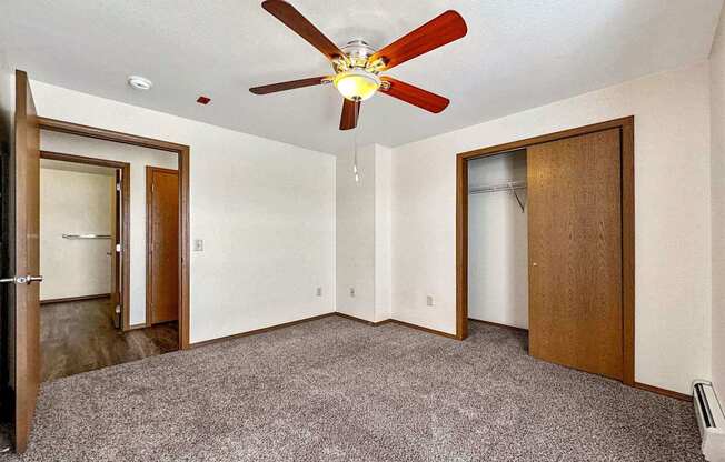 a bedroom with a ceiling fan and a closet