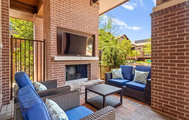 a patio with a brick fireplace and furniture