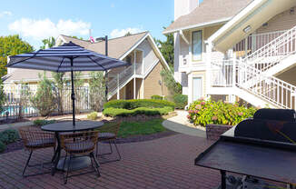 a patio with a table and chairs and an umbrella