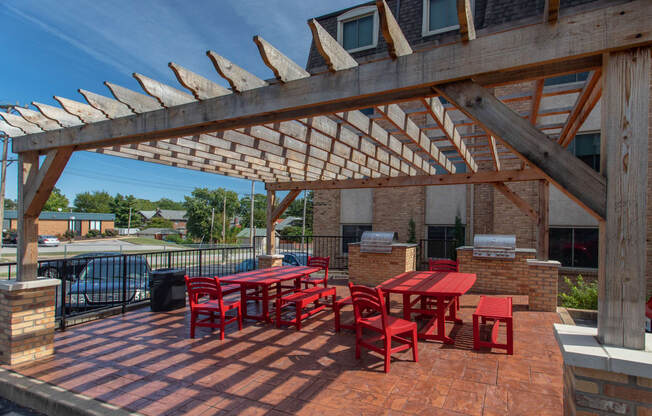 a patio with a table and chairs under a wooden roof