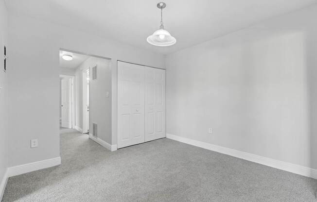 A room with a carpeted floor and a ceiling light.