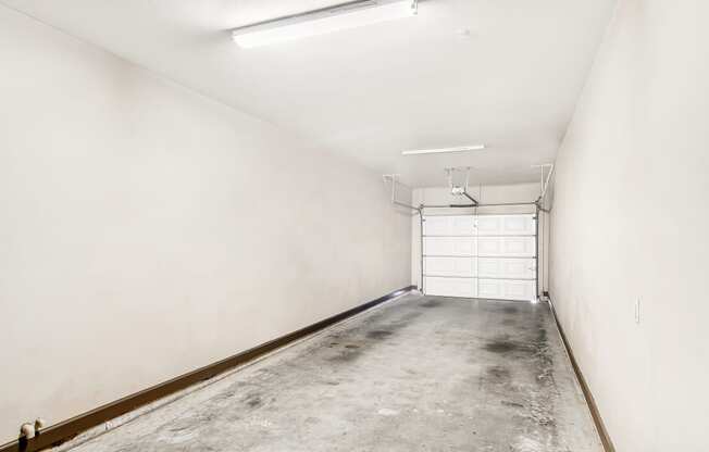 an empty garage with a white wall and a garage door