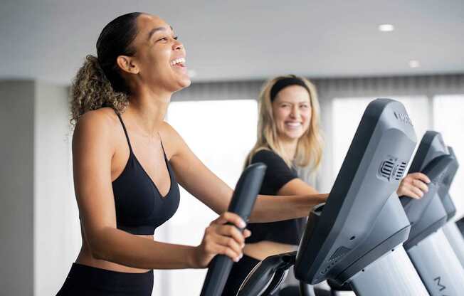 Two women are exercising on treadmills in a brightly lit room. at Palma, Florida