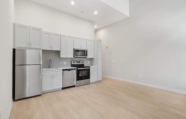 A kitchen with white cabinets and stainless steel appliances.