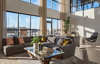 a living room with large windows and a couch and a table