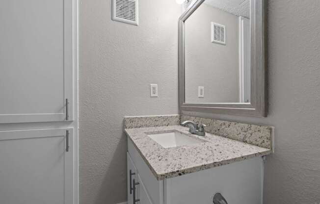 A bathroom with a sink and mirror.