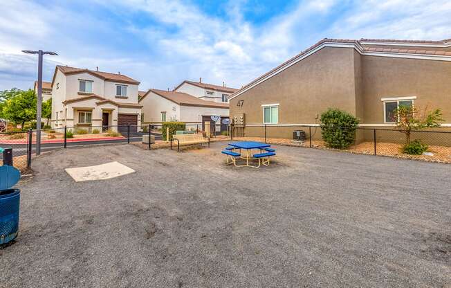 the backyard of a house with a picnic table and a fence