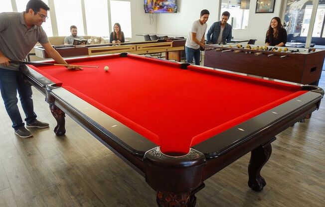 A man is about to hit a pool ball with a cue stick.