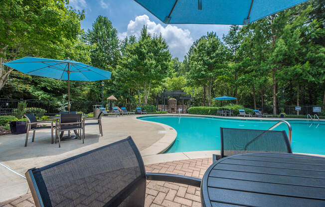 a swimming pool with chairs and umbrellas