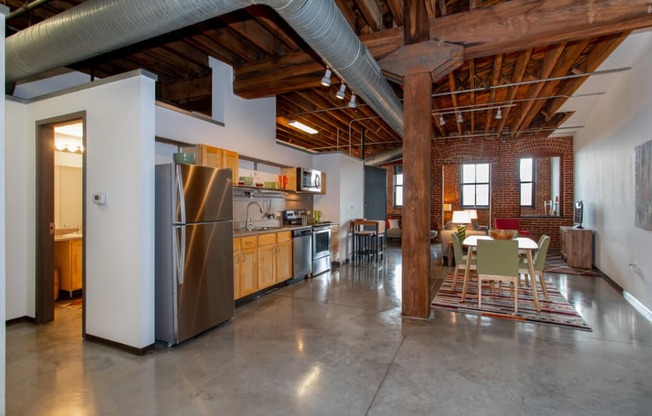 a large kitchen with stainless steel appliances and a dining table