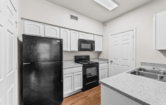 the preserve at ballantyne commons apartment kitchen with black appliances and white cabinets