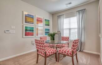 A dining room with a table and chairs.