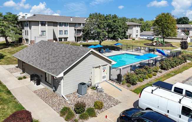 A swimming pool is surrounded by a fence and a building.