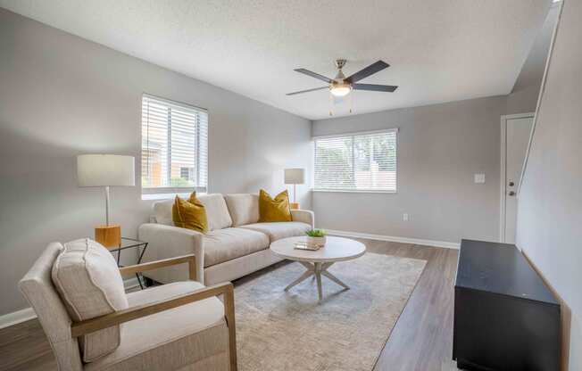 a living room with a couch and a ceiling fan