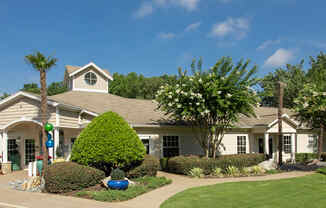 a house with a lawn and trees in front of it