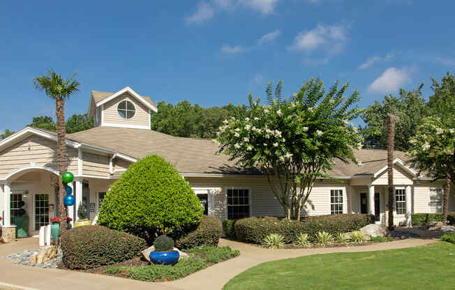 a house with a lawn and trees in front of it