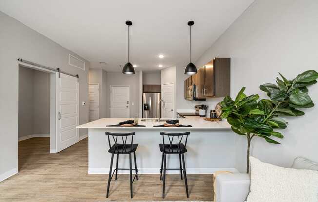 a kitchen with a white counter top and two black stools at EagleRidge Plaza Residences, Fargo, ND, 58104