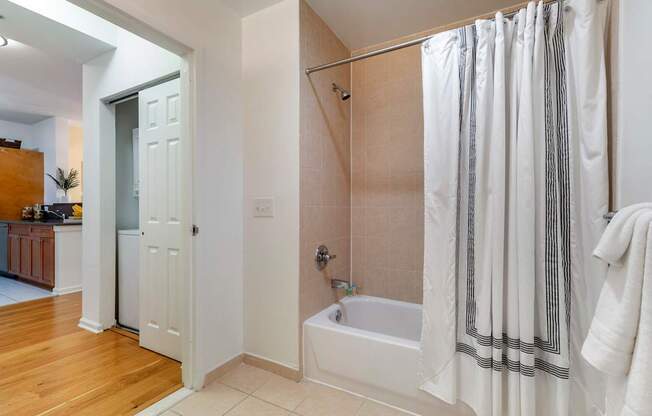 a bathroom with a shower and a tub and a door to a closet at Pier Village Apartments, Long Branch, NJ