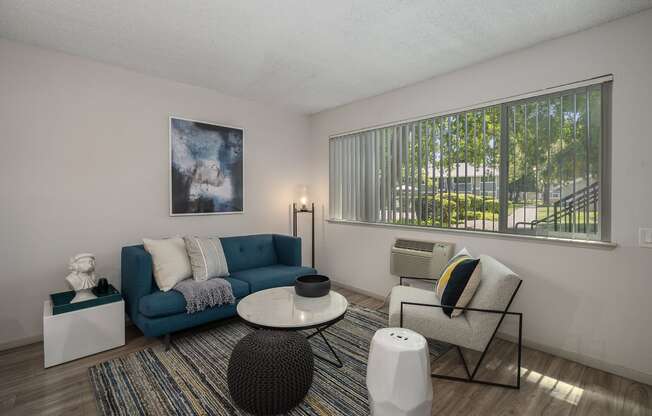 a living room with a blue couch and two chairs