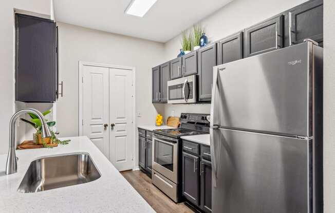 a kitchen with stainless steel appliances and black cabinets