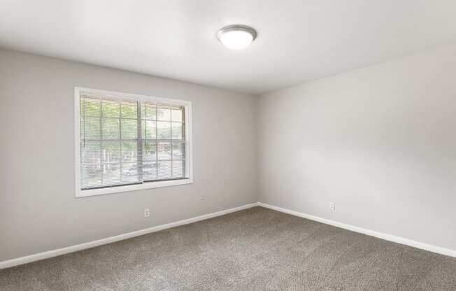 an empty room with carpet and a window