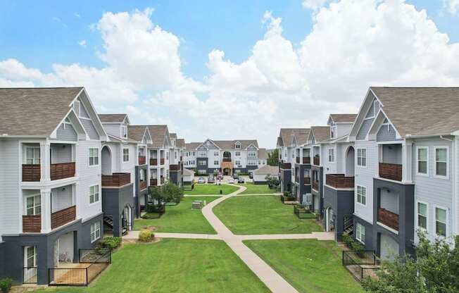 A row of modern townhouses with a grassy area in the foreground.