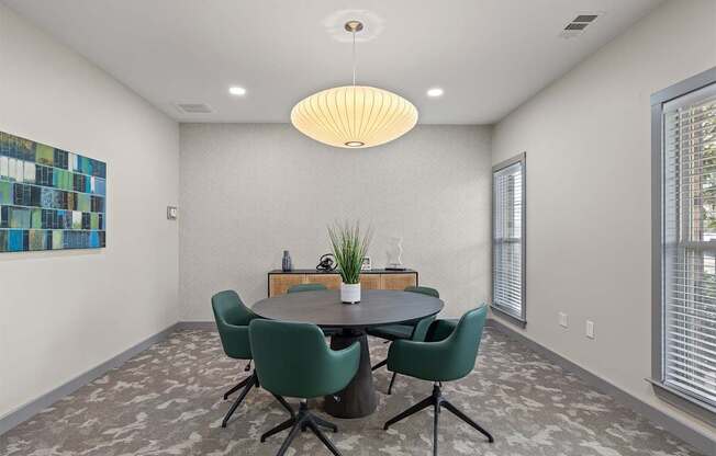 A dining room with a round table and chairs.