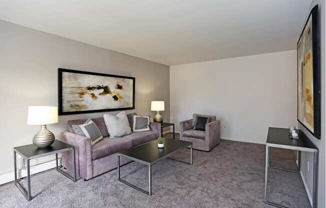 a living room with a couch and chairs and a coffee table