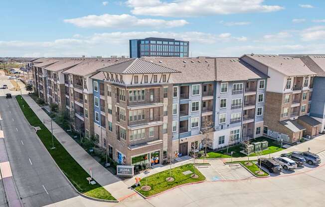 A large apartment complex with a parking lot in front.