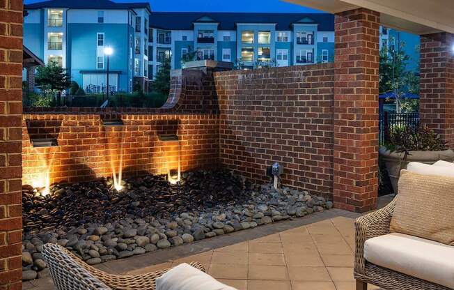 a fire pit in front of a brick wall