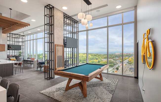 a clubhouse with a pool table and a view of the city