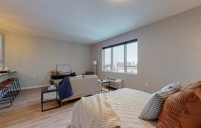 a bedroom with a couch and a chair next to a window