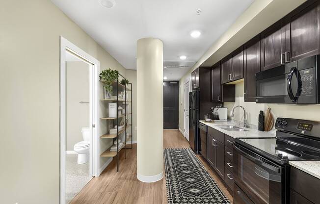 a kitchen with dark wood cabinets and a black stove
