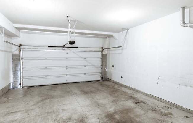 A white garage with a closed white door and a white ceiling at The Landing Apartments and Townhomes, Oregon, 97045