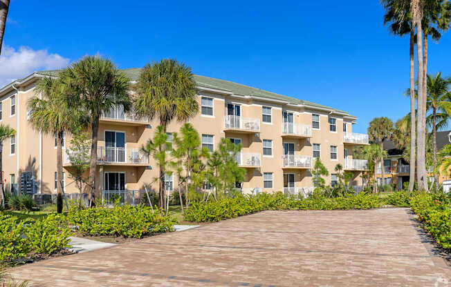 A large apartment complex with a driveway in front.