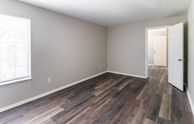 an empty living room with wood flooring and a white door