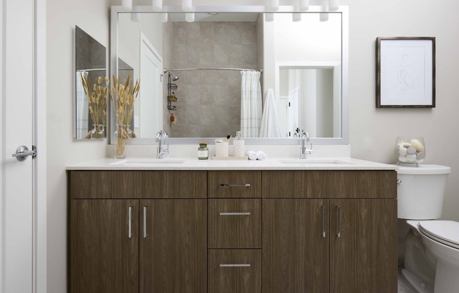 Experience luxury in every detail with designer bathrooms at Modera Clarendon, featuring double vanities, quartz countertops, and backlit mirrors for added elegance and functionality.