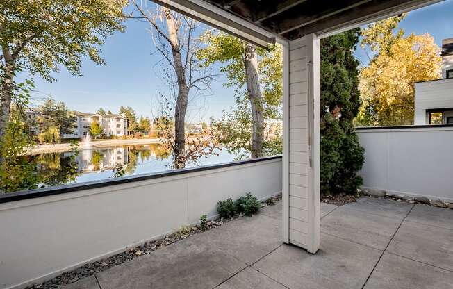 A patio with a view of a lake and trees.