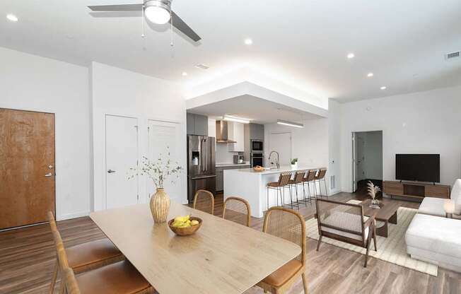 A modern dining room with a wooden table and chairs.