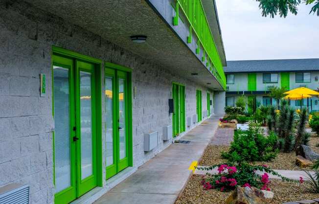 Fusion Las Vegas apartment building interior courtyard with blooming desert landscaping and lime green railing on second story.