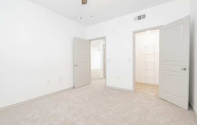 a bedroom with white walls and white doors and a carpeted floor