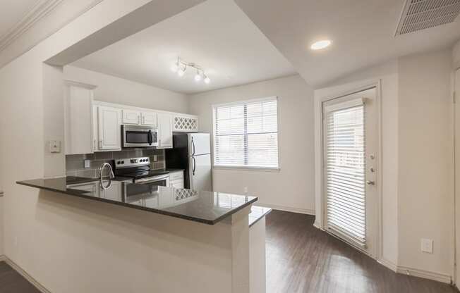 This is a picture of the kitchen of the 1320 square foot 2 bedroom, 2 and 1/2 bath floor plan at The Brownstones Townhome Apartments in Dallas, TX..